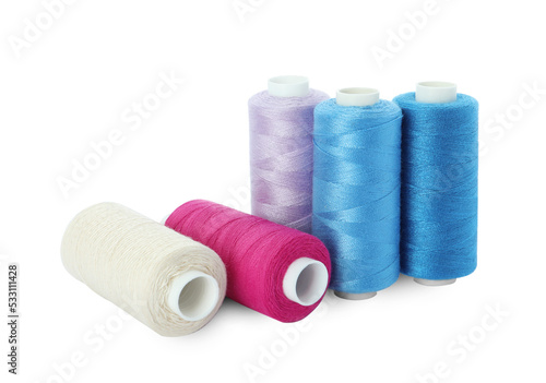 Many different colorful sewing threads on white background