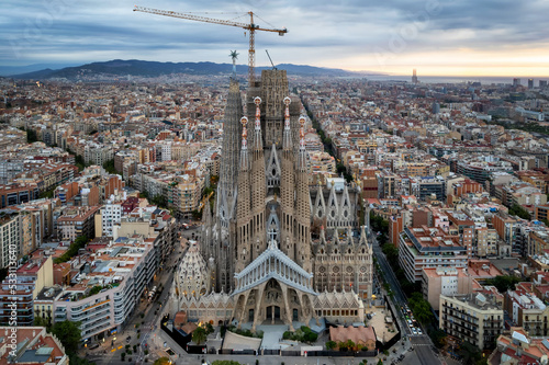 Sunrise drone aerial of the Basilica Sagrada Familia, the iconic church that has been in construction for over a century but is scheduled for completion in 2026.