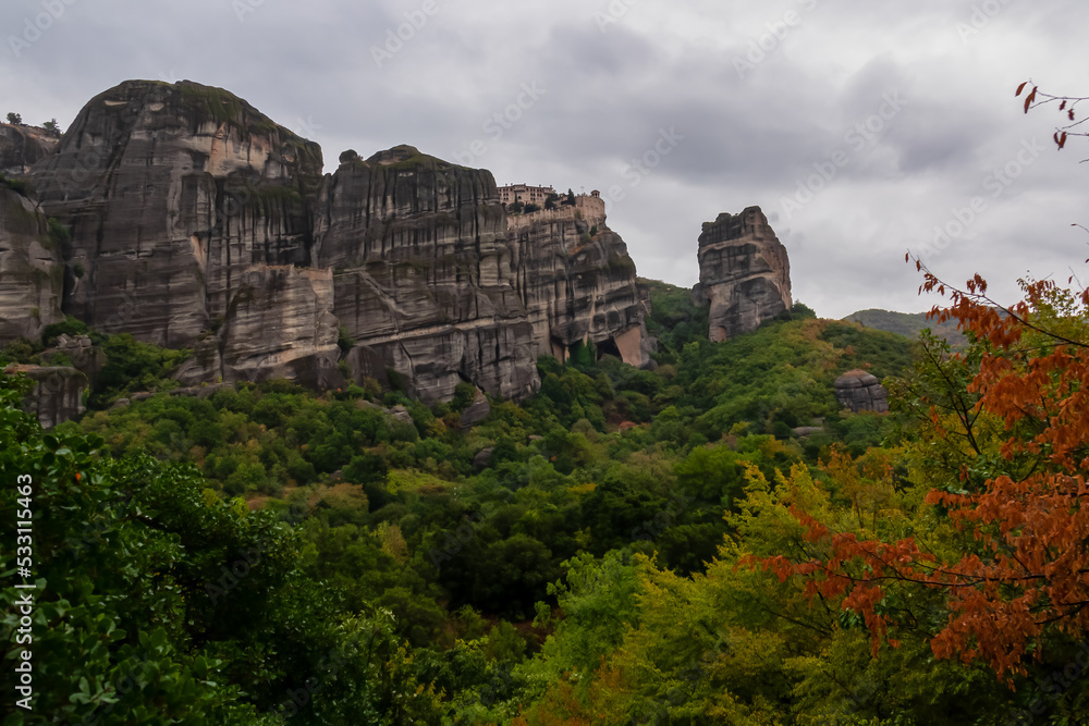 Scenic view of  Holy Monastery of St Nicholas Anapafsas seen from forest on cloudy day, Kalambaka, Meteora, Thessaly, Greece, Europe. Dramatic landscape. Landmark build on unique rock formations