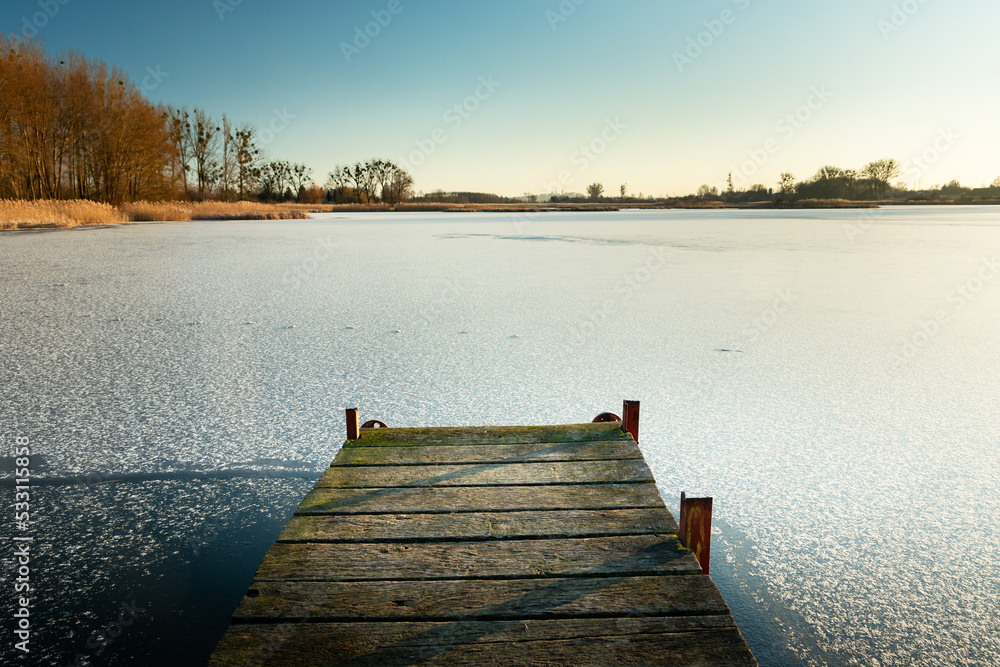 Wooden pier towards the frozen lake, Stankow eastern Poland