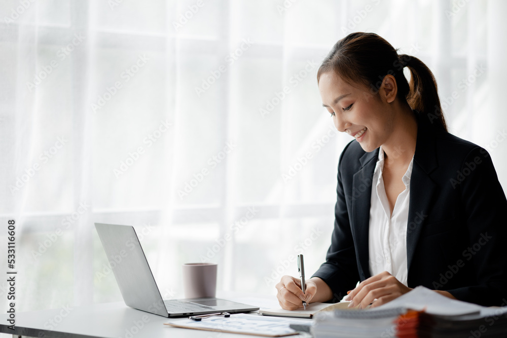 A businesswoman is checking company financial documents and using a tablet to talk to the chief financial officer through a messaging program. Concept of company financial management. A businesswoman is checking company financial documents and using a tablet to talk to the chief financial officer through a messaging program. Concept of company financial management.