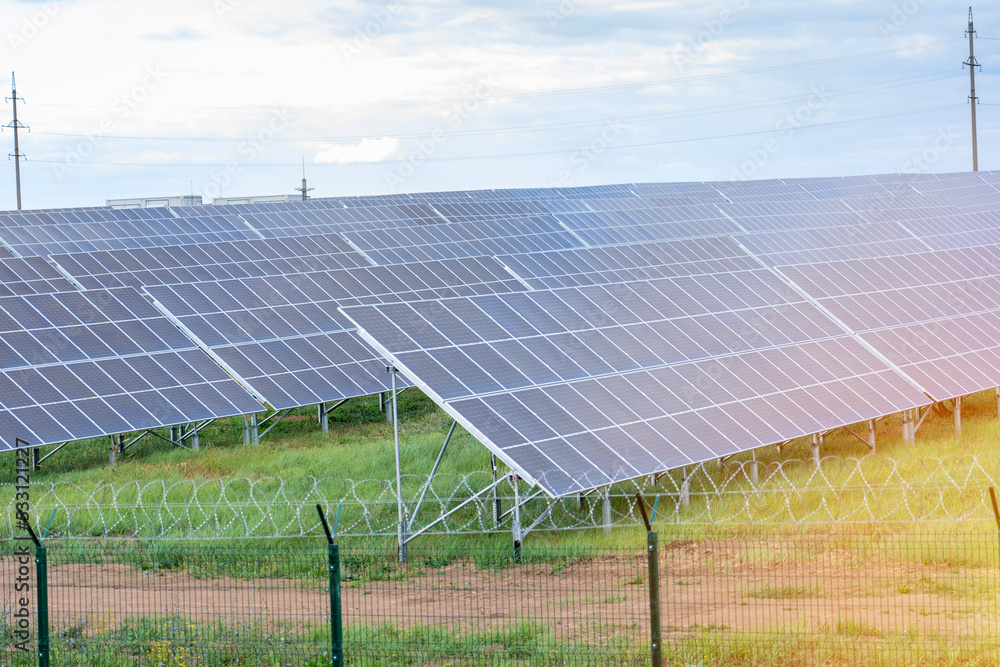 Solar panels in a field fenced with barbed wire Solar panels in a field fenced with barbed wire