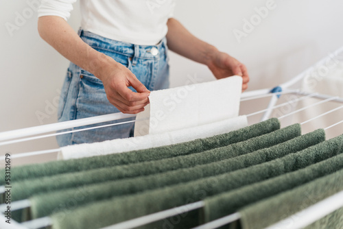 Εκτύπωση καμβά woman hanging clean terry towels on drying rack indoors