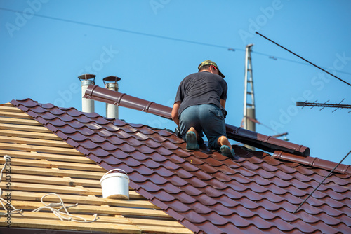 Wallpaper Mural Workers install metal roofing on the wooden roof of a house. Torontodigital.ca
