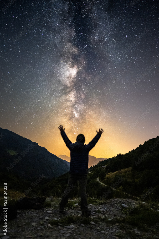 silhouette of a person in the mountains under the milky way