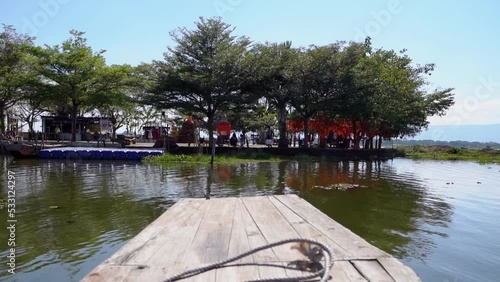 Wooden boat is docking to an island.