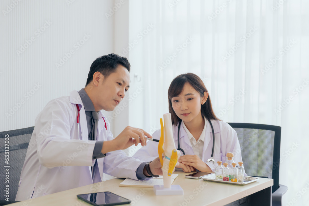 Group of orthopaedic professional doctors working researching or learning knee bone model at hospital Group of orthopaedic professional doctors working researching or learning knee bone model at hospital