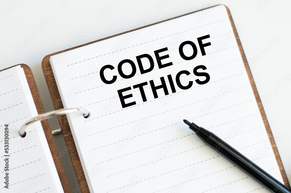 On a white background lies a notebook with words CODE OF ETHICS On a white background lies a notebook with words CODE OF ETHICS
