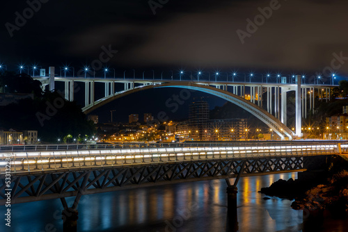 Night cityscape with of the Arrábida Bridge and nightlight, An arch bridge of reinforced concrete which carries six lanes of traffic over the Douro River, between Porto and Vila Nova de Gaia, Portugal