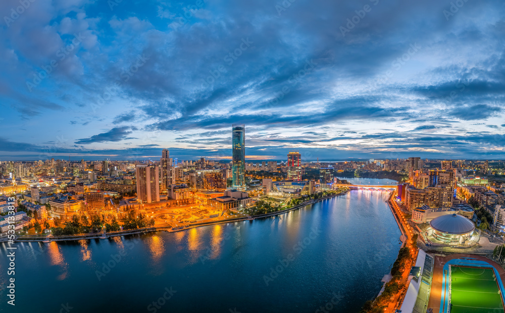 Obraz premium Yekaterinburg city and pond aerial panoramic view at summer or early autumn night. Night city in the early autumn or summer.