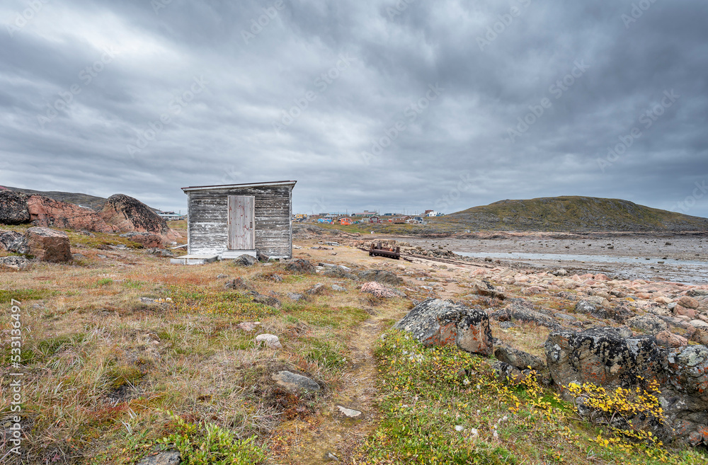 A shed and a distant view of the hamlet of Apex on the edge of the Arctic Ocean in Nunavut A shed and a distant view of the hamlet of Apex on the edge of the Arctic Ocean in Nunavut