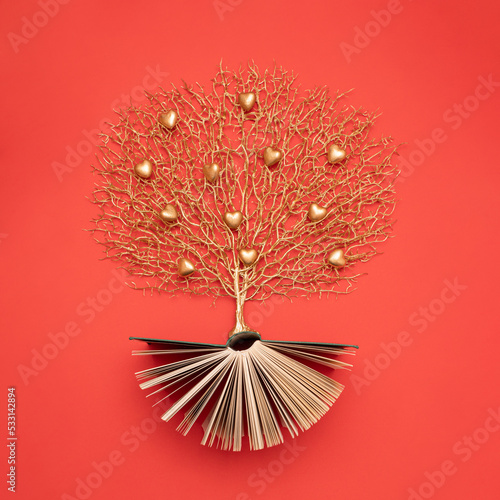 Golden tree with heart shaped fruits growing from the old book  Education and knowledge concept. For book lovers. Flat lay.