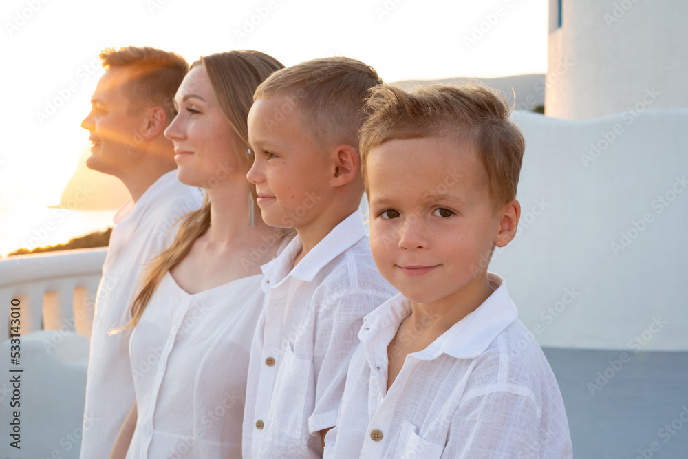 Happy family with children on vacation in Santorini, Greece at sunset. Happy family with children on vacation in Santorini, Greece at sunset.