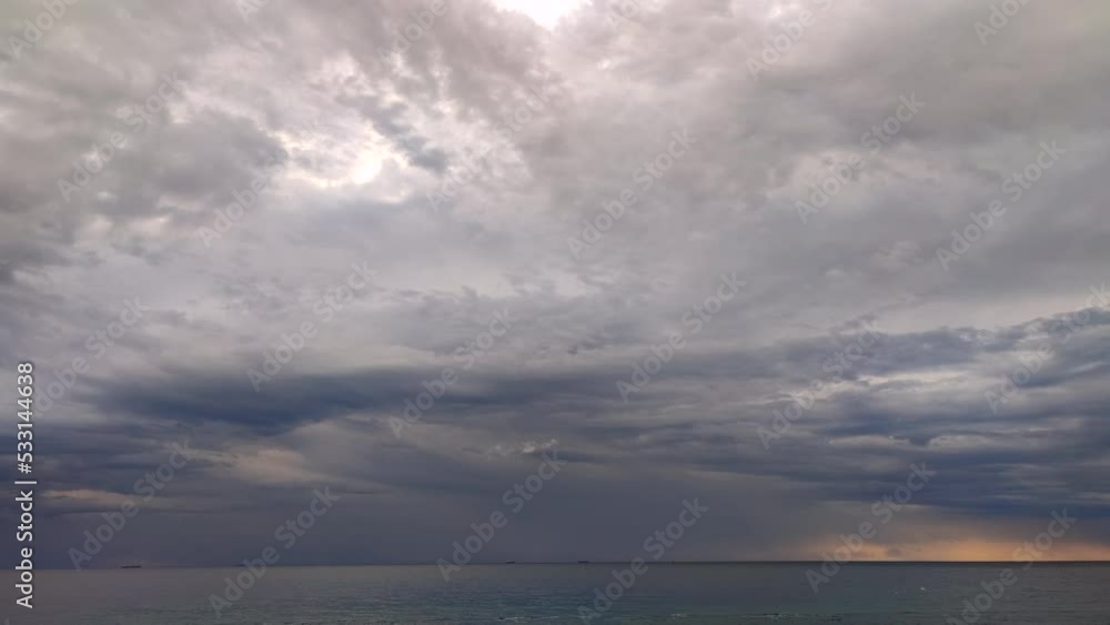 Timelapse. Movement of large dark gray rain clouds and rain on the horizon over the surface of the sea during dawn. Cloudy overcast sea weather. Epic panorama landscape. Beautiful natural background Timelapse. Movement of large dark gray rain clouds and rain on the horizon over the surface of the sea during dawn. Cloudy overcast sea weather. Epic panorama landscape. Beautiful natural background