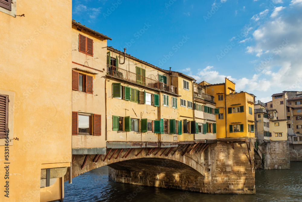 The Ponte Vecchio, Old Bridge, is a Medieval stone closed-spandrel segmental arch bridge over the Arno River, with shops built along it; as jewelers, art dealers and souvenir sellers. Italy, 2019