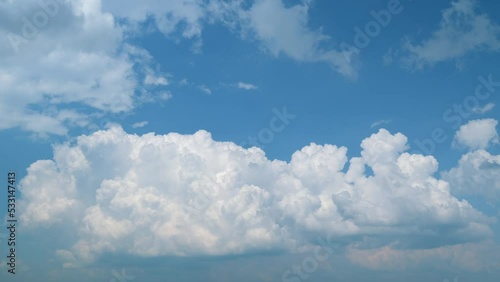 Fluffy cloud passing blue sky. Bubbling bubble of cumulous. Movement of cumulonimbus clouds in distance. Timelapse.