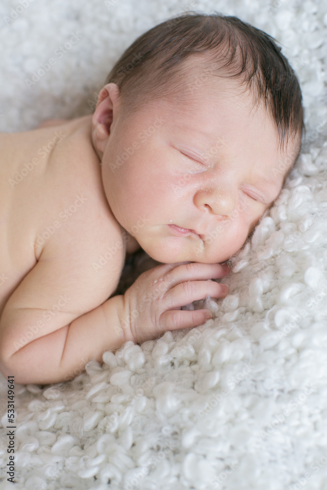 A cute little baby sleeps on a white bouclé bedspread at home. Health and motherhood
A cute little baby sleeps on a white bouclé bedspread at home. Health and motherhood