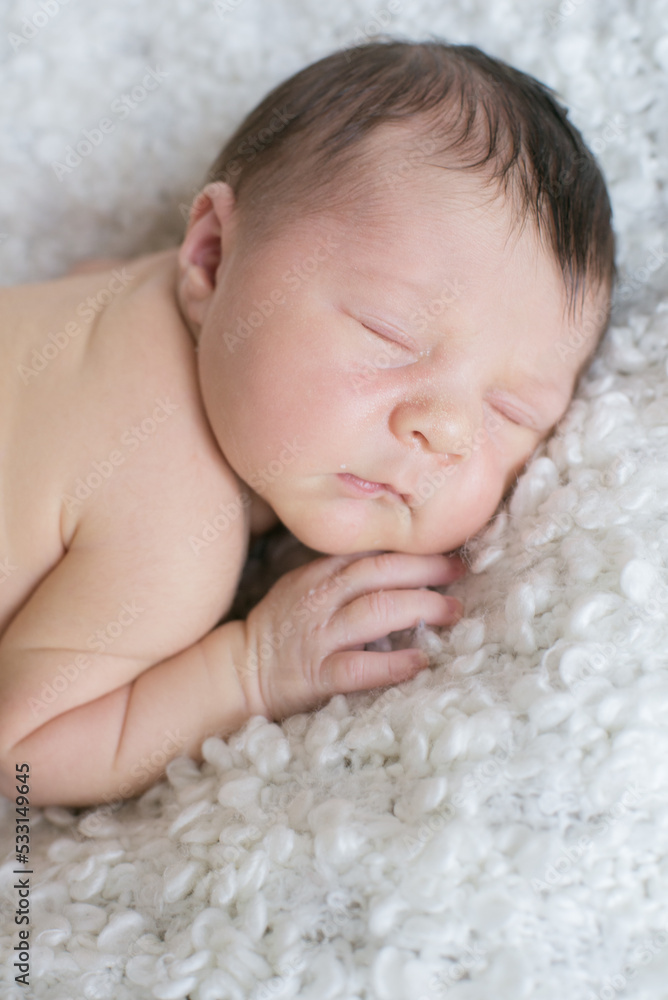 A cute little baby sleeps on a white bouclé bedspread at home. Health and motherhood
A cute little baby sleeps on a white bouclé bedspread at home. Health and motherhood