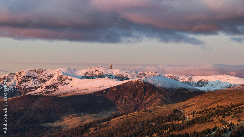 First snow on the peak of the Koralpe and first rays of sun on a cold winter morning in Austria