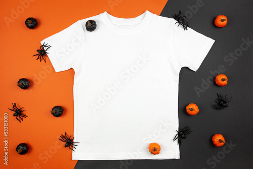 White womens cotton t-shirt halloween mockup with pumpkins and spiders on black orange background. Design t shirt template, print presentation mock up. Top view flat lay.