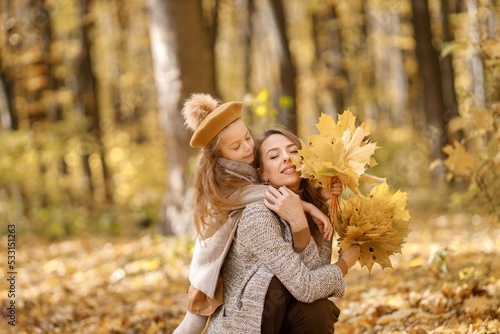 Mother and her daughter playing and having fun in autumn forest