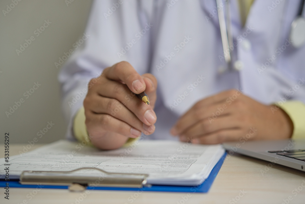 Obraz premium Doctor uniform working hand holding pen clipboard document medicine profession paper hospital health care on desk.