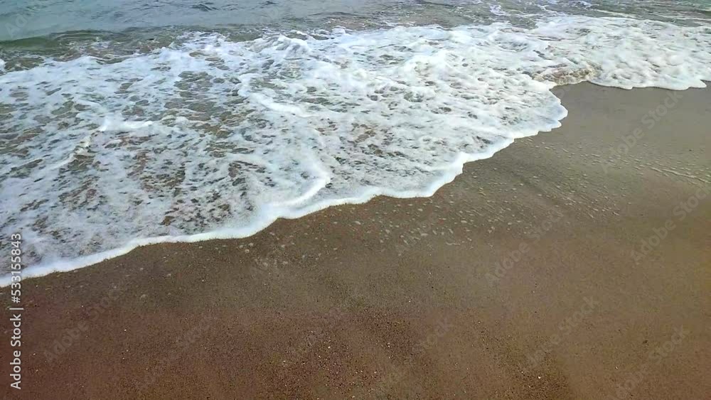 Sea waves with white foam roll on the sandy beach of the seashore close-up. Sand tropical and exotic coast shoreline. Sea waves close-up. Coastal maritime. Natural background. Summer nature backdrop. Sea waves with white foam roll on the sandy beach of the seashore close-up. Sand tropical and exotic coast shoreline. Sea waves close-up. Coastal maritime. Natural background. Summer nature backdrop.