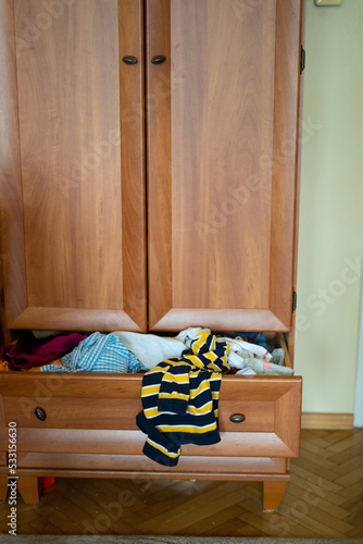 Spring cleaning,Fast fashion,girl puts things order closet. A bunch of colorful clothes.concept of processing, second hand, eco, minimalism, consumption of goods