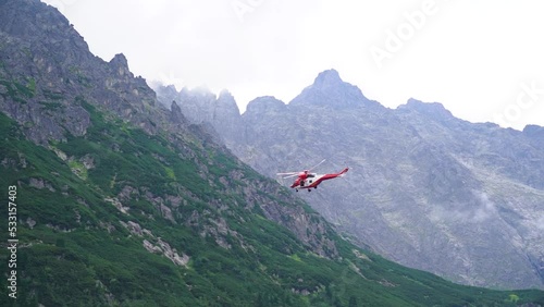 extreme slow motion flying rescue helicopter near mountains with fog. Poland photo