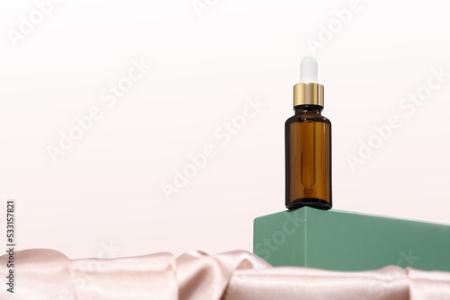 Bild auf Leinwand amber glass bottle with dropper or pipette on a green podium or pedestal, hero shot