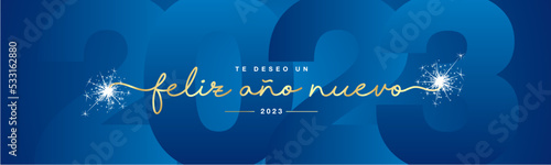 We wish you Happy New Year 2023 Spanish language golden line designed handwritten lettering white blue background with sparkle firework