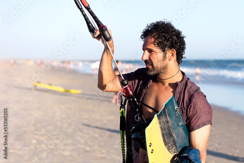Young man on the beach after practicing kitesurfing. Selective focus.
