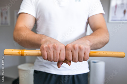 the therapist uses a bamboo stick tool to treat pain.