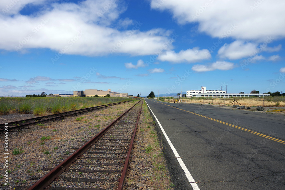 Wide open area with rusty train tracks and abandoned industrial and military buildings Wide open area with rusty train tracks and abandoned industrial and military buildings
