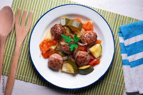 Beef meatballs with tomato sauce and assorted vegetables. Typical Spanish tapas recipe.
