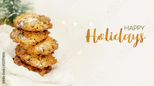 Christmas and New Year gift card. Winter holiday card with natural handmade oatmeal cookies and holiday decoration on a white background with congratulation inscription