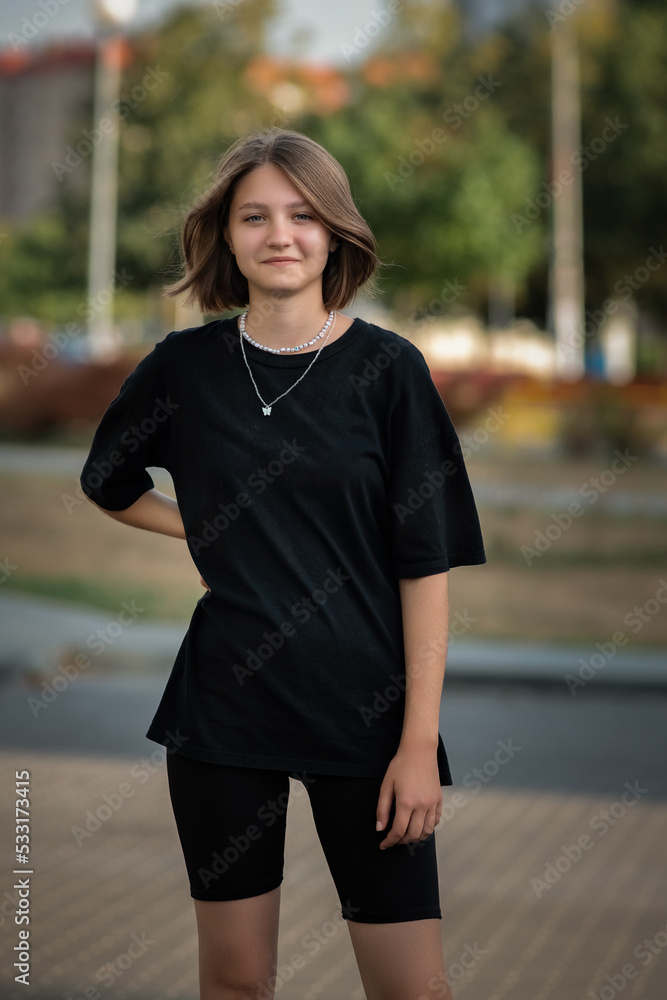Portrait of a young beautiful blonde girl in dark clothes outdoors. Portrait of a young beautiful blonde girl in dark clothes outdoors.