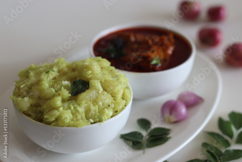 Mashed tapioca served with pomfret fish curry. Boiled and strained tapioca pieces mashed with spiced coconut taste best with fish curry prepared in Kerala style photo