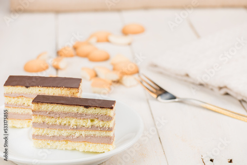 Hungarian Dobos cake also known as Dobosh. Pastry made from biscuit dough, chocolate buttercream and topped with chocolate topping. Two slices of famous sweet bakery from Hungary.  photo