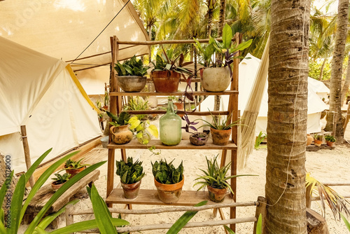 Beautiful Mexican beach tent hotel or hostel. Tents in the jungle decorated with plants and flowers, Tulum, Mexico