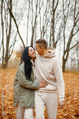 Lovely couple standing in autumn forest and kissing