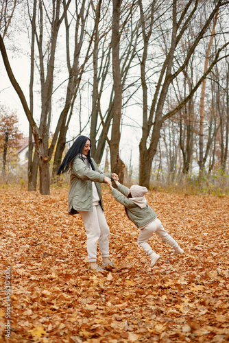 Mother with her daughter playing in autumn forest © prostooleh