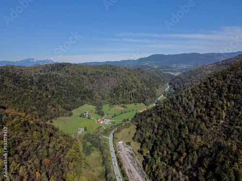 Aerial drone view road between hills with forest