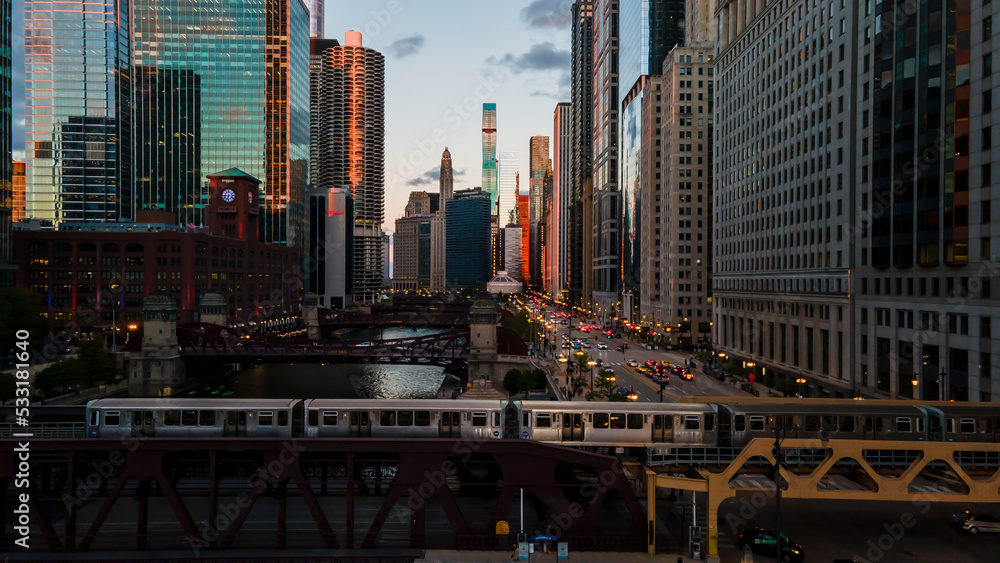 Obraz premium aerial drone view of the Chicago river during sunset and Chicagohenge. during golden hour the sun is clearly visible in the sky due to the fall equinox as people go about their commute 