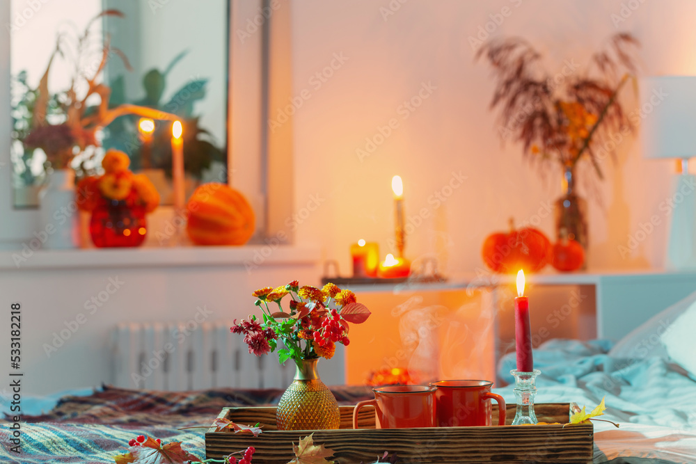 cup of tea and chrysanthemum in vase with burning candles in bedroom cup of tea and chrysanthemum in vase with burning candles in bedroom