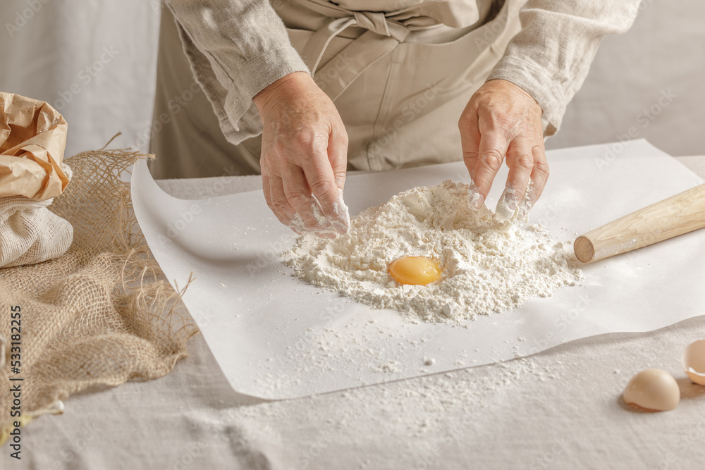 Women’s hands, flour and dough. A woman is preparing a dough for home baking. Concept of home cooking with organic and natural ingredients. Zero waste concept Women’s hands, flour and dough. A woman is preparing a dough for home baking. Concept of home cooking with organic and natural ingredients. Zero waste concept