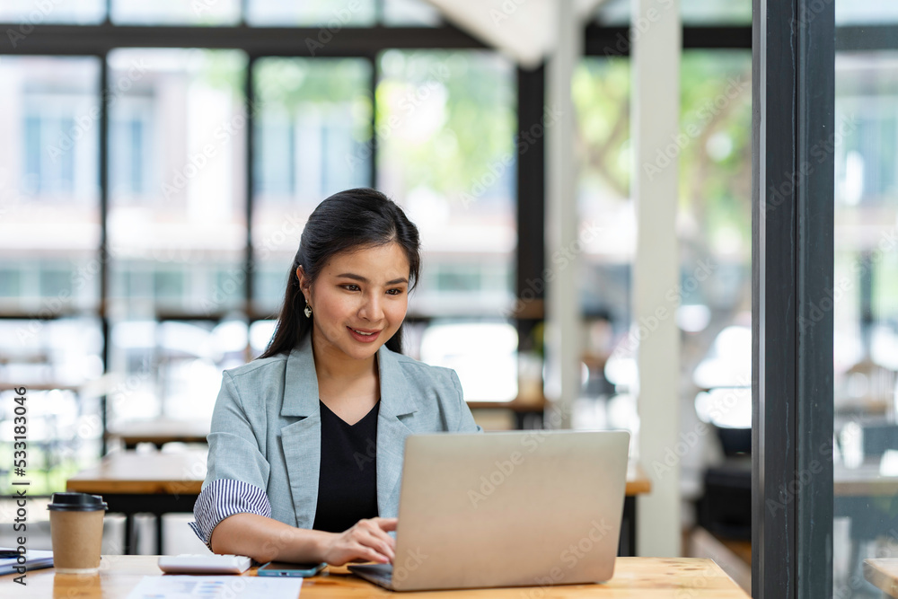 Asian businesswoman working with laptop at her desk in the modern office Asian businesswoman working with laptop at her desk in the modern office