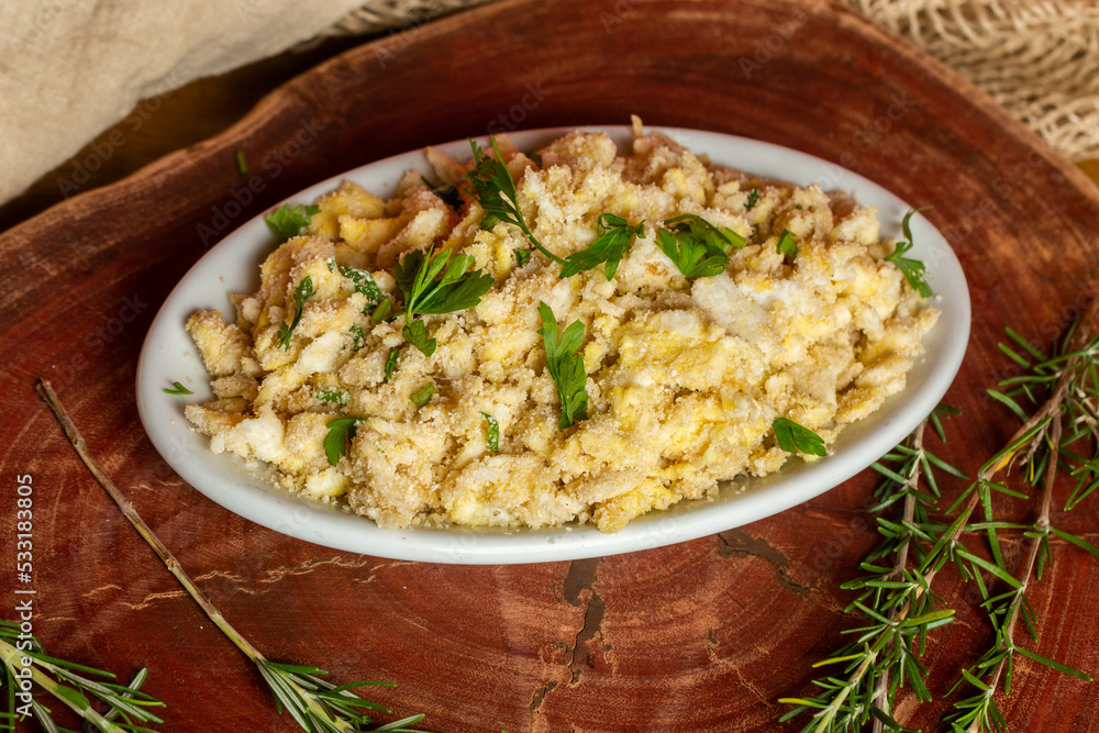 Portion of manioc farofa with eggs, typical Brazilian dish called farofa de ovos Portion of manioc farofa with eggs, typical Brazilian dish called farofa de ovos
