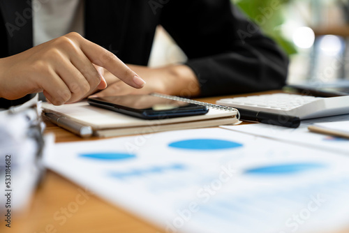 Close-up hand of a woman using smartphone at the table in the office