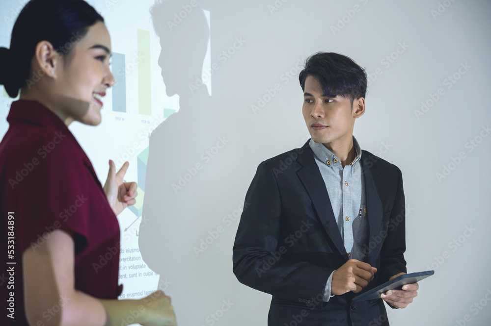 Business man and woman gives presentation to colleagues during meeting, Shows Infographics Animation on Big Screen. Business man and woman gives presentation to colleagues during meeting, Shows Infographics Animation on Big Screen.